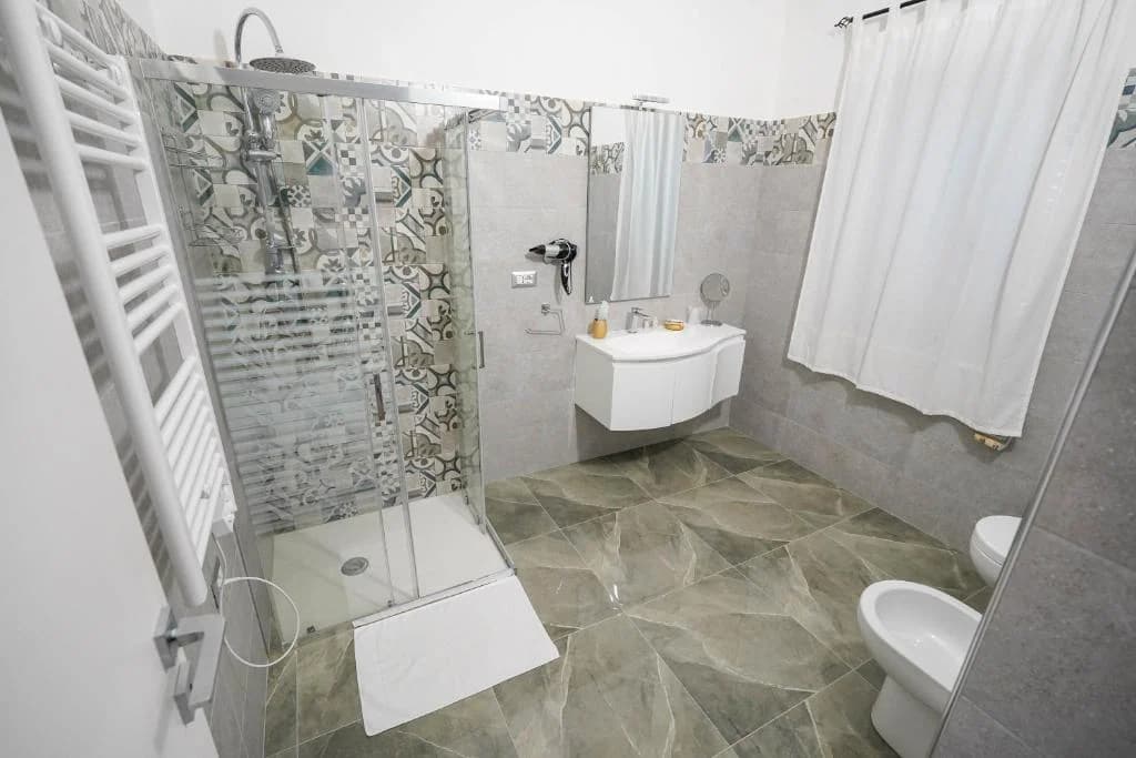 Bagno luminoso della Queen Deluxe con doccia e lavabo