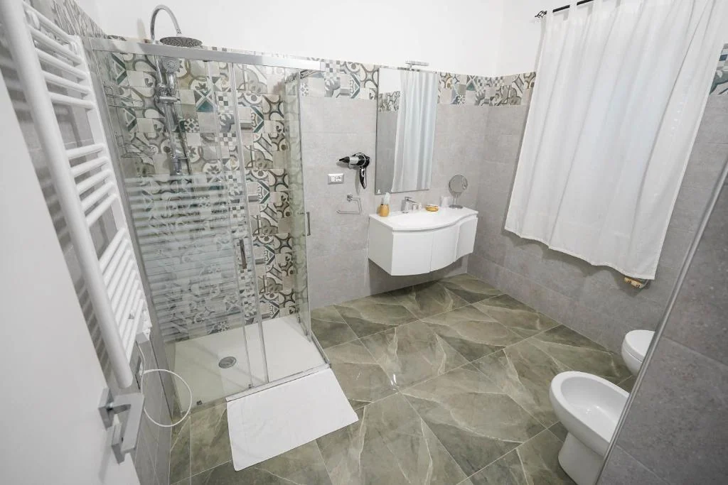 Bagno luminoso della Queen Deluxe con doccia e lavabo