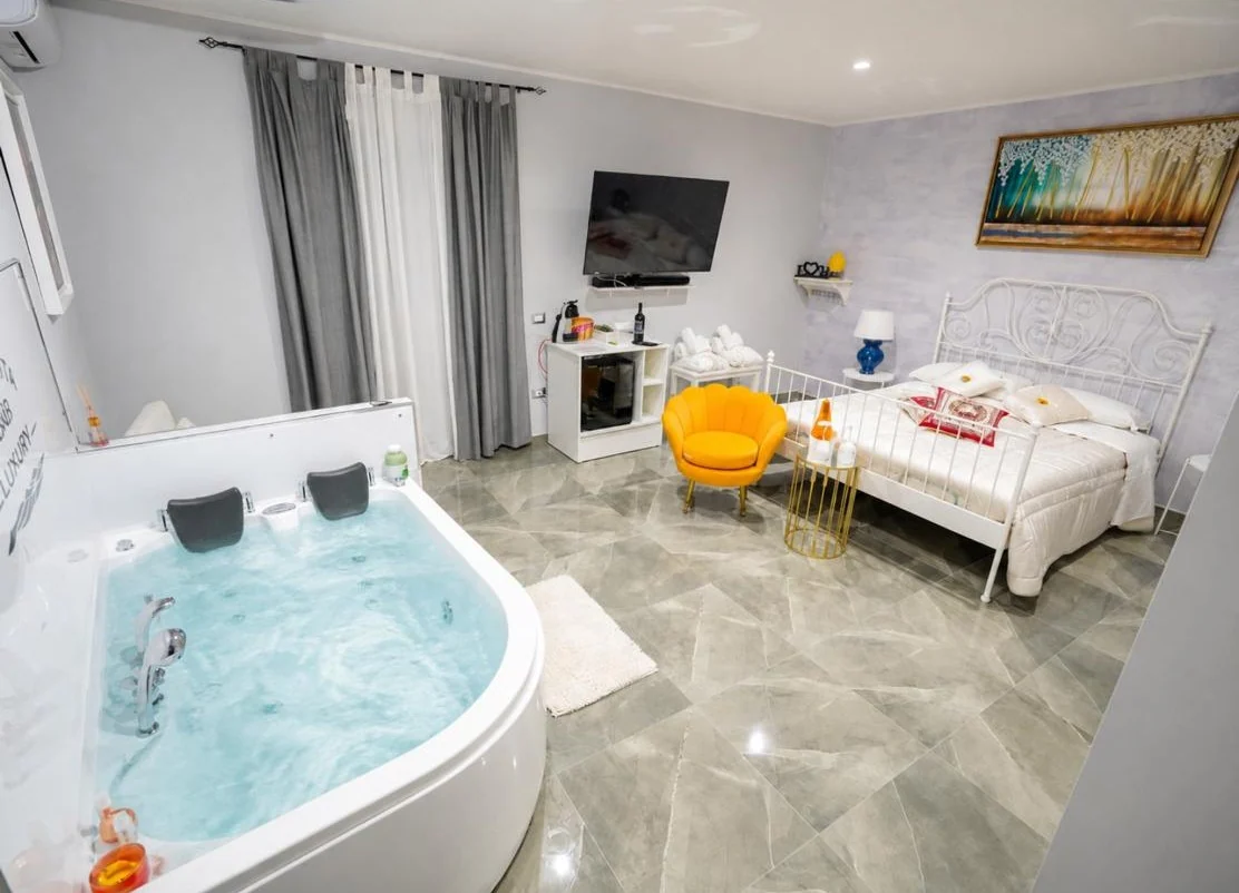 Queen Deluxe con idromassaggio pieno d’acqua e area lounge a Piedigrotta Magique Luxury